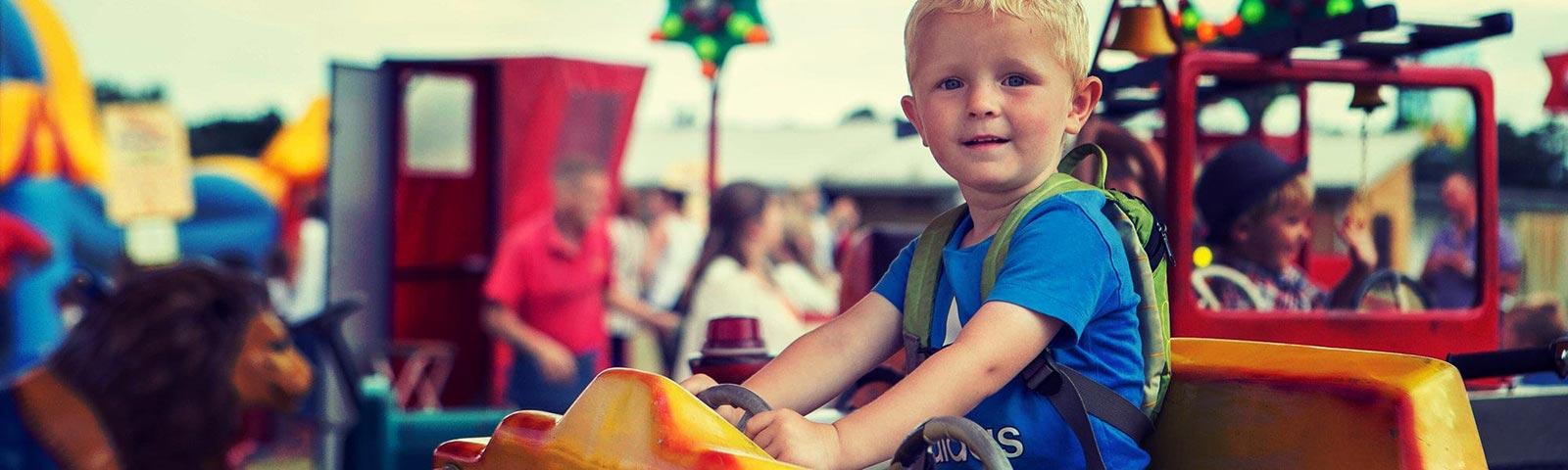 A young boy sat on a merry-go-round type ride.