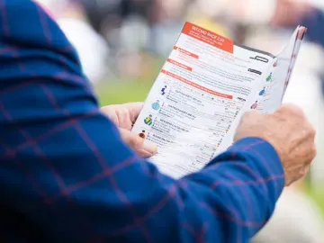 A racegoer in a suit studies the racecard at Great Yarmouth