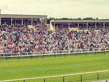 Crowds standing in the grandstand at Great Yarmouth Racecourse.