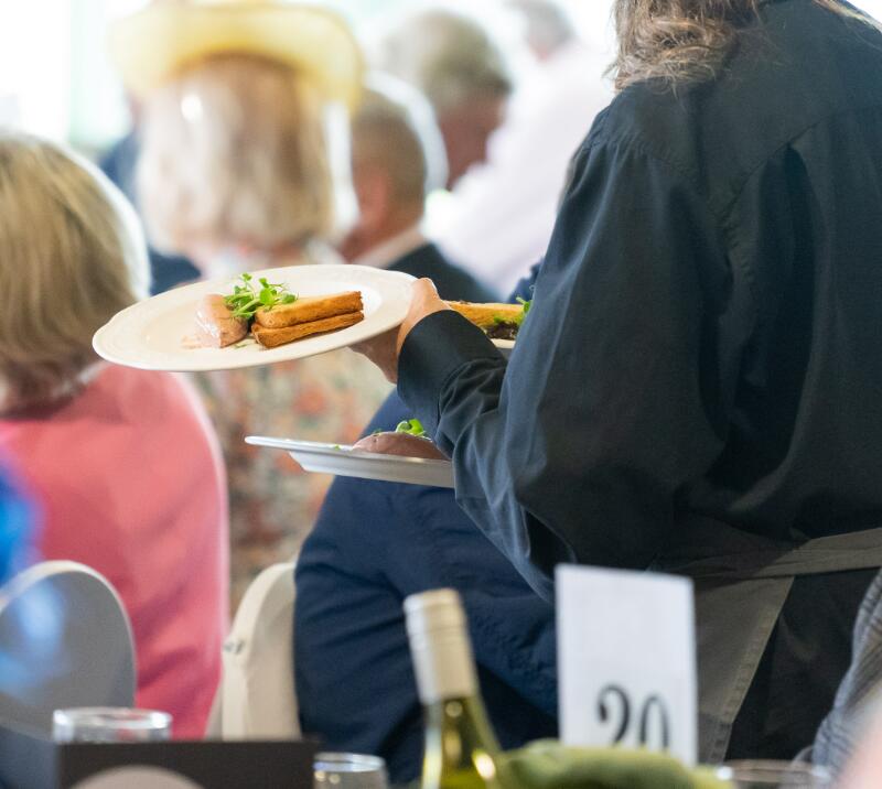A member of waiting staff at Great Yarmouth Races carries food to hospitality guests