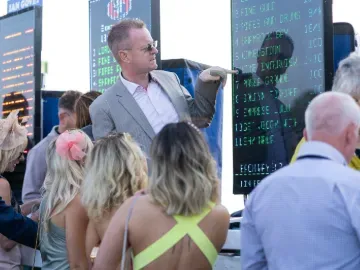 A bookmaker talking through the odds with a group of race goers