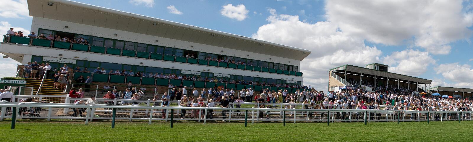 View of the racecourse buildings from the track with crowd