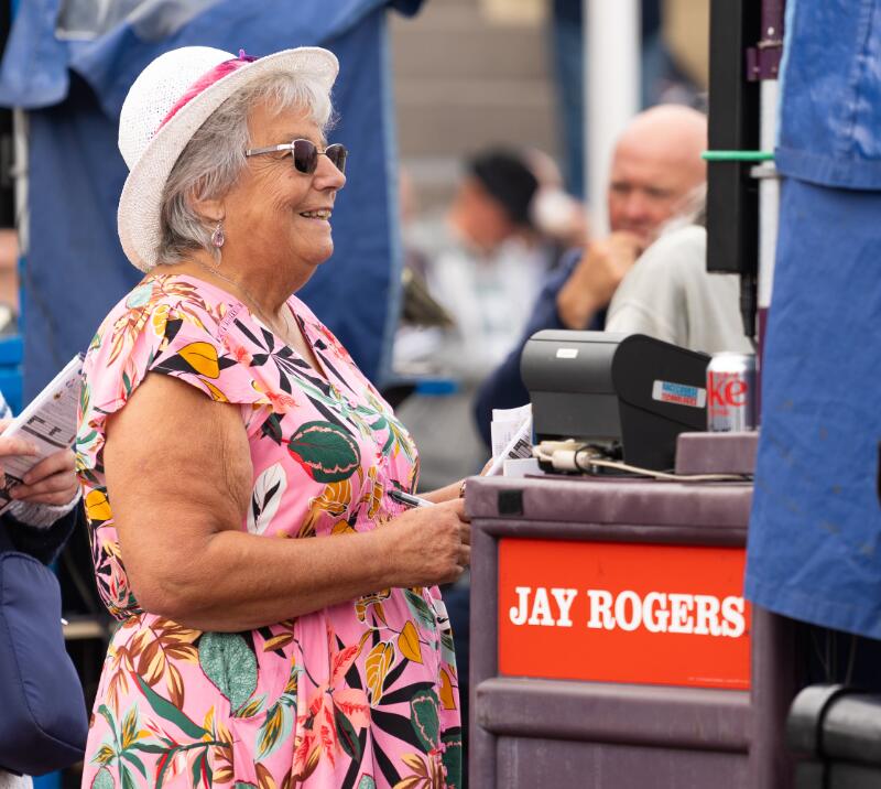 A race goer holds on to a racecard while placing a bet at Great Yarmouth Races