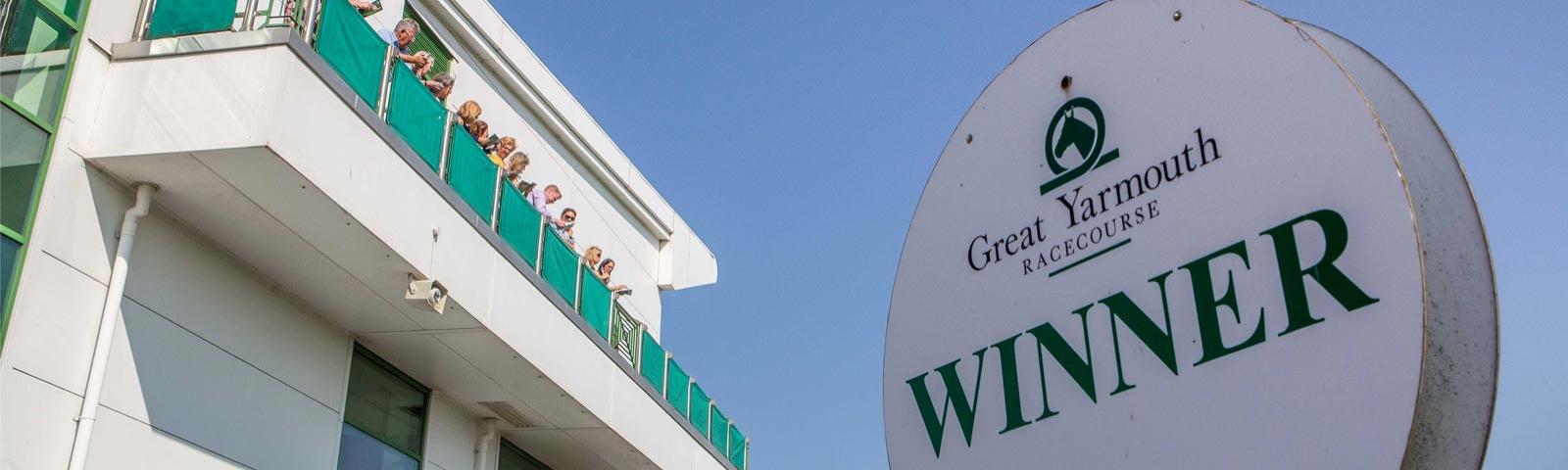 Close up on a winners sign with the grandstand in the background at Great Yarmouth Racecourse.