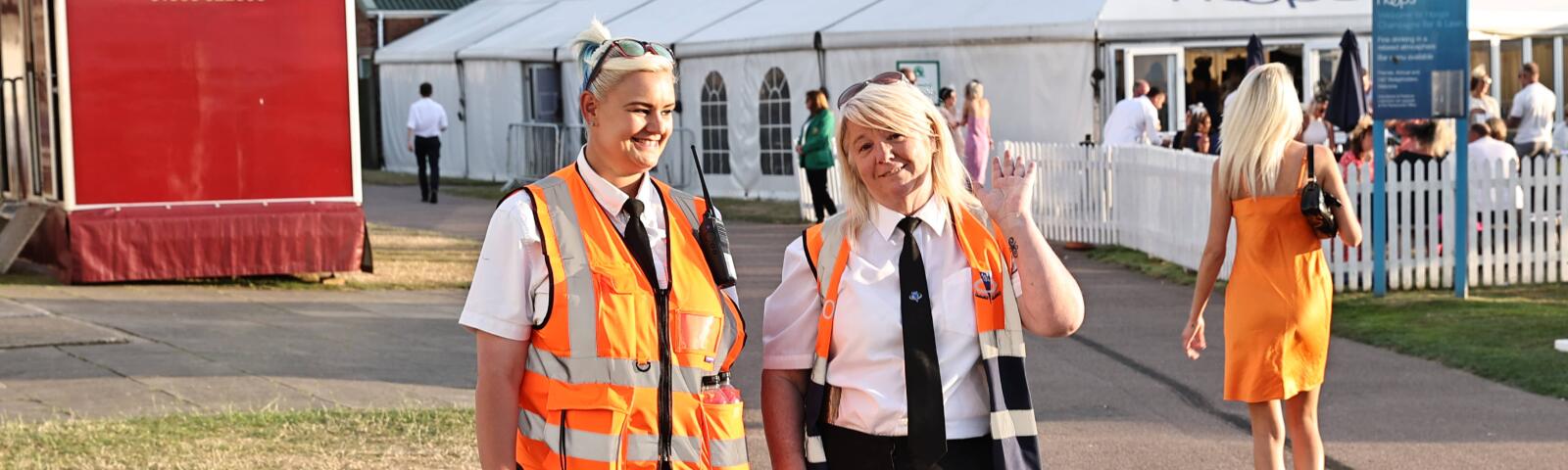 Two stewards at Great Yarmouth races wave to the camera