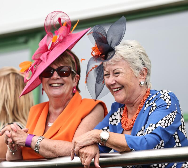 Two beautifully dressed hospitality guests smiling at Great Yarmouth Racecourse