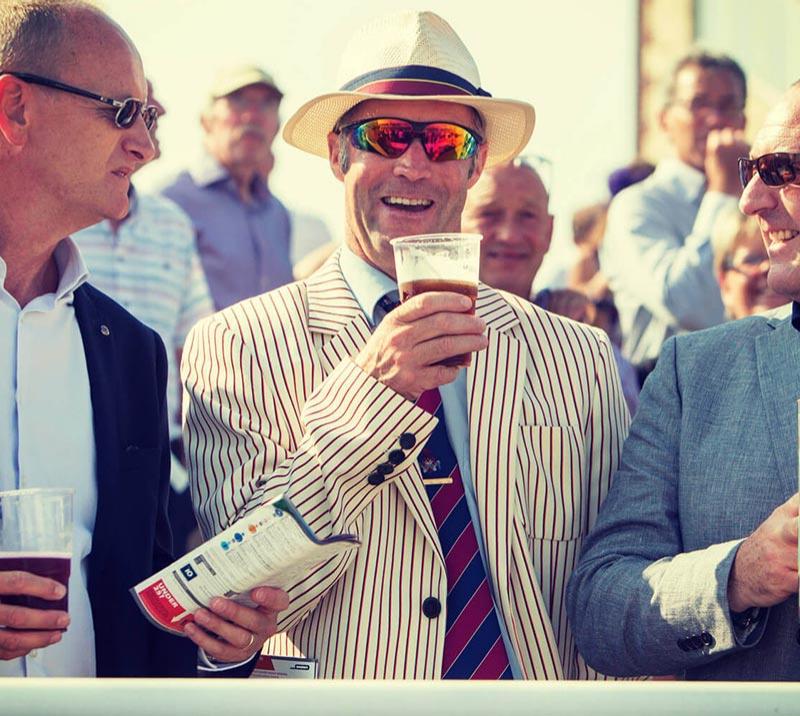 A smiling gentleman holding a glass of beer.