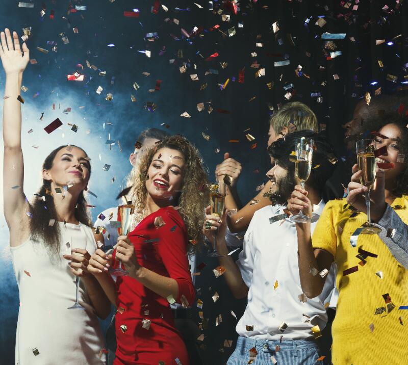 People dancing at a party, holding prosecco, confetti 