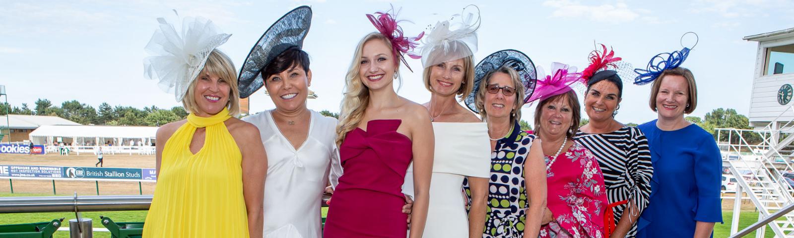 A group of well dressed Ladies pose for the camera on Ladies Day at Great Yarmouth Racecourse.