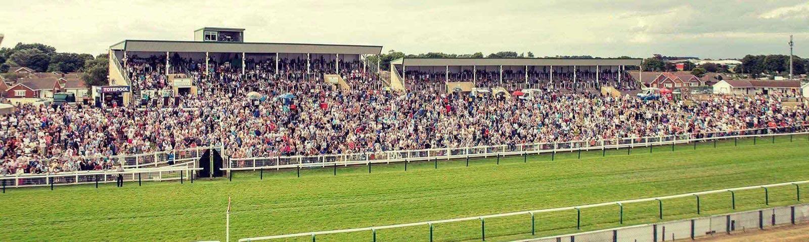 Crowds standing in the grandstand at Great Yarmouth Racecourse.